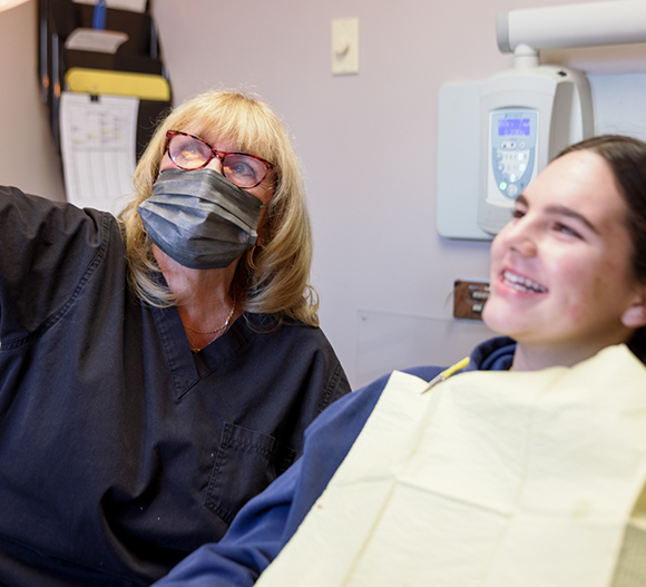 Dental team member showing a patient something out of frame