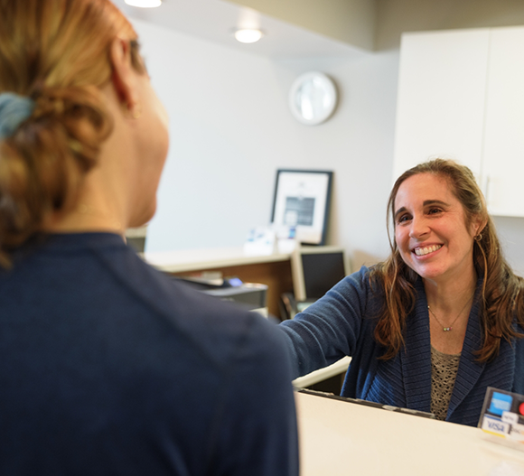 Dental office receptionist smiling at a patient