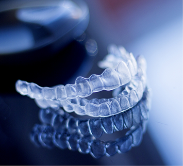Two clear aligners on a flat gray surface