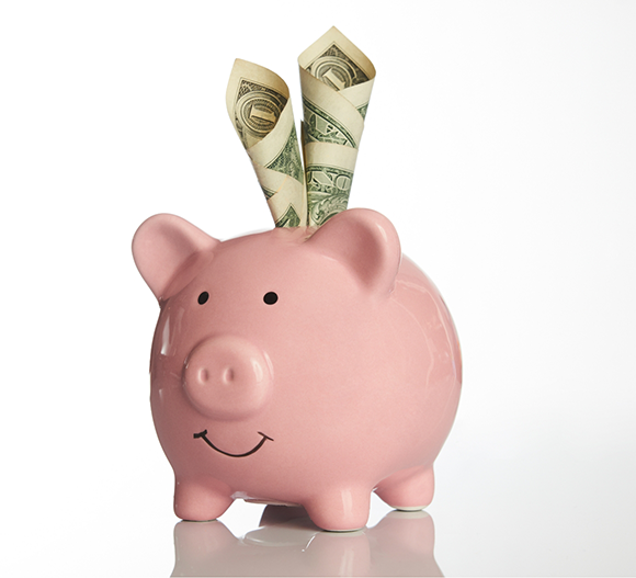 Dollar bills stuffed into a piggy bank