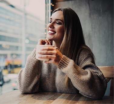 Smiling woman holding a mug in a coffee shop