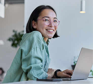 Young woman smiling at a desk with a laptop