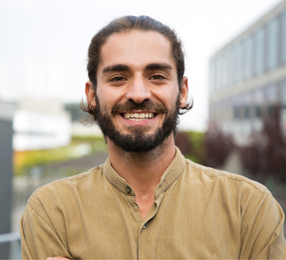 Young smiling man with dark hair and beard