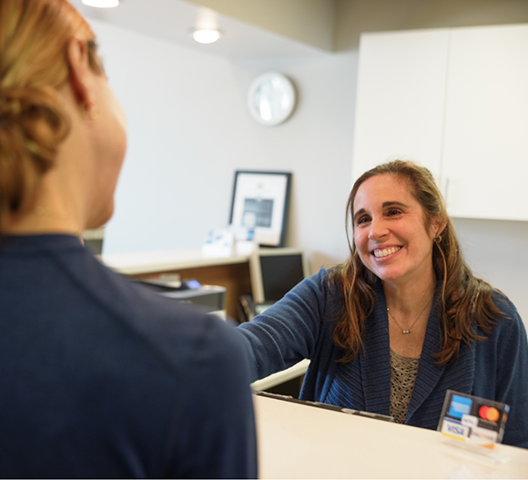 Dental office receptionist smiling at a patient
