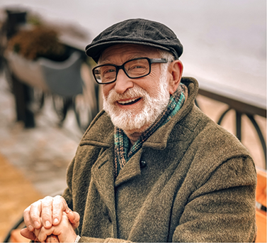 Smiling senior man sitting and holding his cane