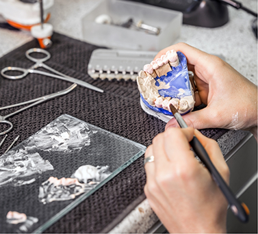 Dental lab worker designing a denture