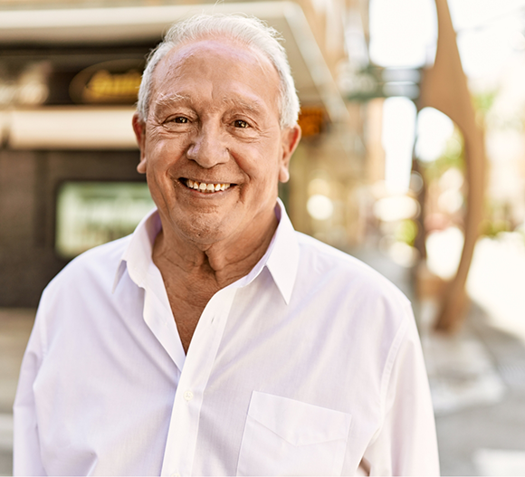Senior man smiling in a white button-down shirt