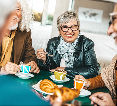 Group of seniors seated at a table in a coffee shop