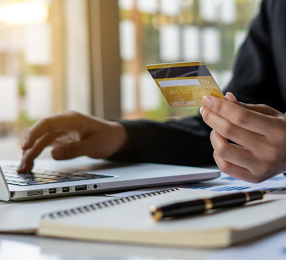 Person entering their credit card information into a laptop