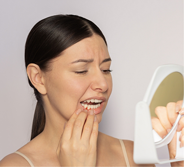 Woman looking at her gums in a mirror
