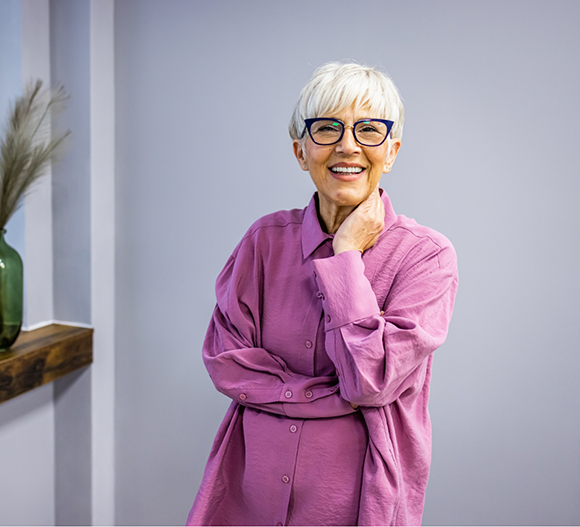 Smiling senior woman in a purple button-down blouse