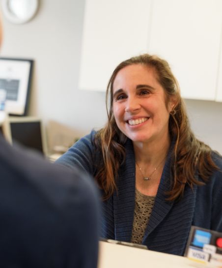 Dental team member at the front desk smiling at a patient
