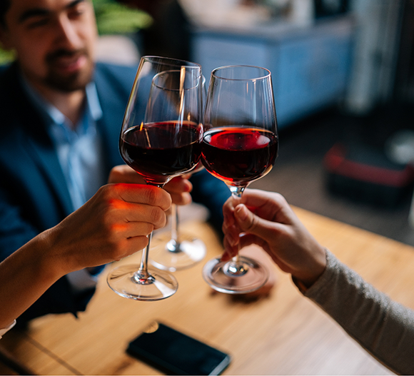 Several people toasting glasses of red wine