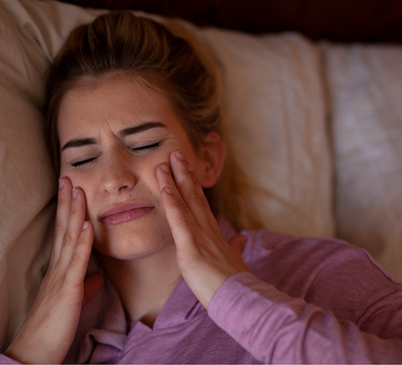 Woman holding her face in pain