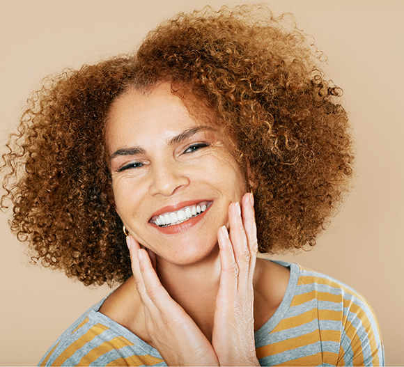 Smiling woman touching her face