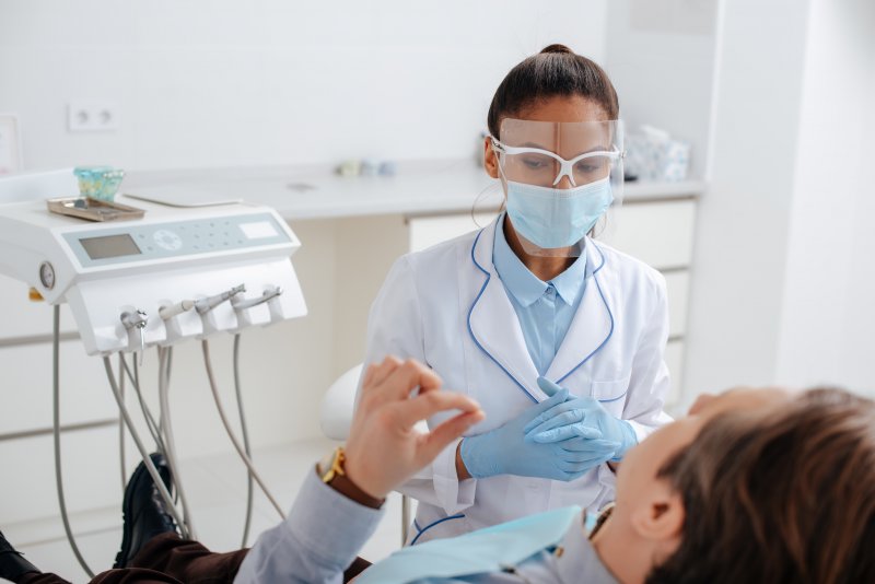Dentist wearing PPE at appointment with patient.