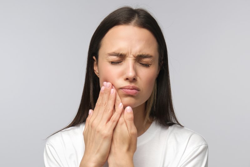 A woman experiencing tooth sensitivity.