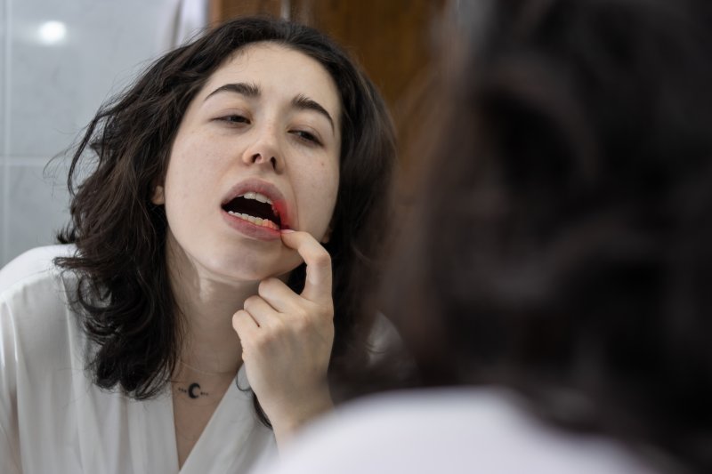 Patient holding her mouth due to inflamed gums.