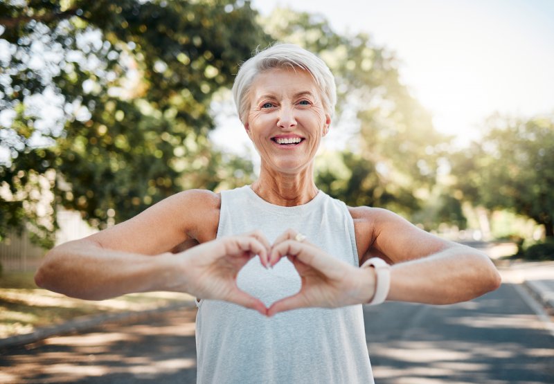 Lady makes shape of heart with her hands.