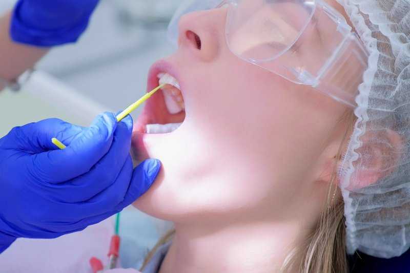 Dentist administering fluoride treatment.