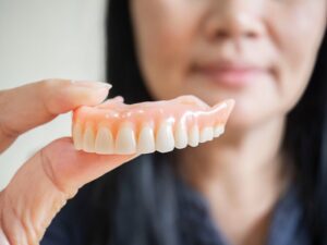 Person holding dentures.